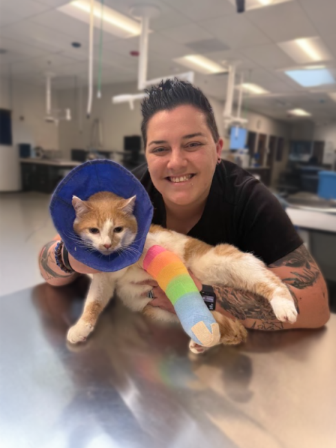 Sara holding a cat with a cast on its leg